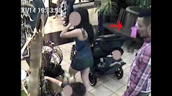 Surveillance footage from International Mall shows a man helping a kid steal an iPhone.
