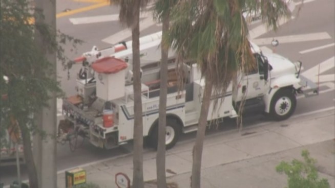 Police were directing cars on the streets after they closed part of NE 163rd Street after power lines fell on some shrubs, causing them to go on fire.