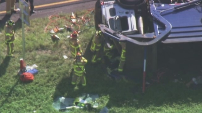 Firefighters worked to free a trapped driver after his garbage truck rolled over on the Turnpike Monday afternoon.