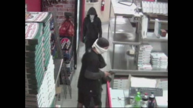 According to the surveillance video, the two men, one of which was armed with a gun, walked into the Papa John's at 50 Indian Trace and held the general manager at gunpoint, demanding he place money inside one of the pizza delivery bags, Weston Police said.