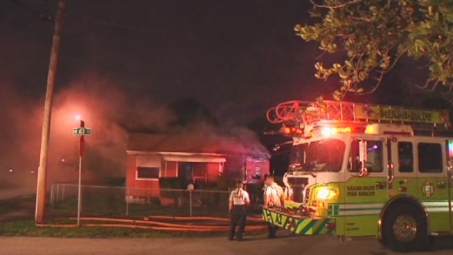 Firefighters battle a fire at a house in Northwest Miami-Dade. Officials say one woman was killed in the fire.