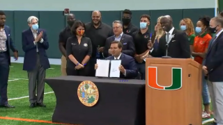 Florida Gov. Ron DeSantis signs a bill allowing college athlete compensation at the University of Miami on June 12, 2020.
