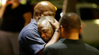 Worshippers embrace following a group prayer across the street from the scene of a shooting at Emanuel AME Church, June 17, 2015, in Charleston, South Carolina.