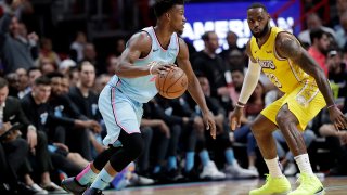 Miami Heat forward Jimmy Butler, left, drives to the basket as Los Angeles Lakers forward LeBron James (23) defends during the first half of an NBA basketball game, Friday, Dec. 13, 2019, in Miami.