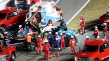 Rescue aid Ryan Newman after he was involved in a wreck on the last lap of the NASCAR Daytona 500 auto race at Daytona International Speedway, Monday, Feb. 17, 2020, in Daytona Beach, Florida. Newman had been in the lead for the last lap when another car's bumper caught his and flipped him.