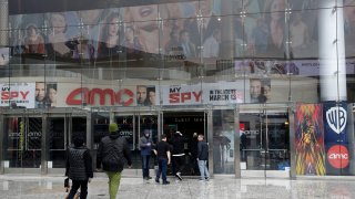 People enter an AMC theater in Los Angeles.