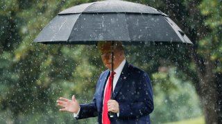 President Donald Trump walks in the rain on the South Lawn of the White House