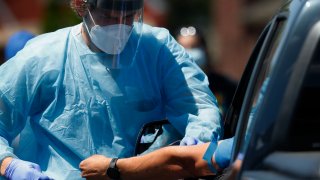 FILE - In this June 12, 2020, file photo, a health worker draws blood for COVID-19 antibody testing in Dearborn, Mich.