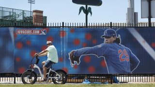 A cyclist rides past Principal Park, home to the Triple-A minor league baseball Iowa Cubs, Thursday, June 25, 2020, in Des Moines, Iowa. Two high school baseball games scheduled for Thursday at the stadium were postponed after officials said a ballpark staff member tested positive for coronavirus.