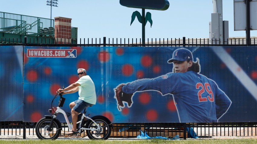 A cyclist rides past Principal Park, home to the Triple-A minor league baseball Iowa Cubs, Thursday, June 25, 2020, in Des Moines, Iowa. Two high school baseball games scheduled for Thursday at the stadium were postponed after officials said a ballpark staff member tested positive for coronavirus.