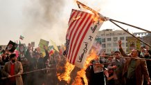 Iranian pro-government demonstrators burn makeshift US flags as they gather in the capital Tehran's central Enghelab Square on November 25, 2019, to condemn days of "rioting" that Iran blames on its foreign foes. - In a shock announcement 10 days ago, Iran had raised the price of petrol by up to 200 percent, triggering nationwide protests in a country whose economy has been battered by US sanctions.