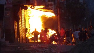 A shop burns as a mob sets it on fire during violence between two groups in New Delhi, India, Tuesday, Feb. 25, 2020. At least 10 people were killed in two days of clashes that cast a shadow over U.S. President Donald Trump's visit to the country.