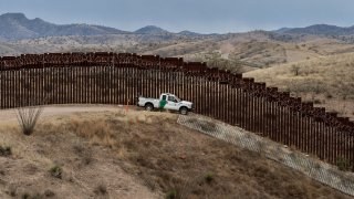 Border Patrol car in front of Arizona border wall