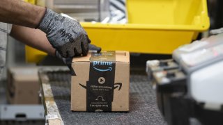 An employees places a label on a box at the Amazon.com Inc. fulfillment center in Baltimore, Maryland