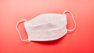 Still life of a face mask on red background