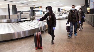 Sukhneet Dhillon (L), age 11, and her family arrives on a flight from India that went through Tokyo at the SeattleTacoma International Airport (also known as Sea-Tac Airport) on March 8, 2020 in Seattle, Washington.