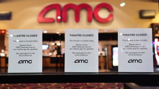 "Theater Closed" signs are posted in front of an AMC movie theater