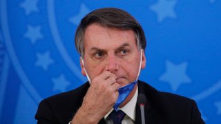 In this March 20, 2020, photo, Brazil's President Jair Bolsonaro attends a press conference on the coronavirus pandemic at the Planalto Palace in Brasilia, Brazil.