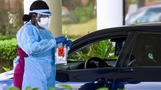 MELBOURNE, FLORIDA, UNITED STATES – APRIL 8, 2020:
A healthcare worker seals a biohazard bag containing a coronavirus nasal swab on the second day of a drive-thru COVID-19 test collection facility operated by Omni Healthcare. The facility is prepared to test at least 500 people per day, seven days a week, by appointment.- PHOTOGRAPH BY Paul Hennessy / Echoes Wire/ Barcroft Studios / Future Publishing (Photo credit should read Paul Hennessy / Echoes Wire/Barcroft Media via Getty Images)