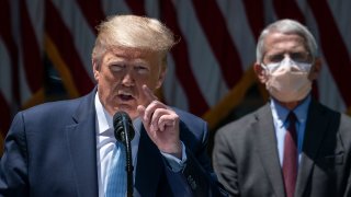 Dr. Anthony Fauci (R), director of the National Institute of Allergy and Infectious Diseases, looks on as U.S. President Donald Trump delivers remarks about coronavirus vaccine development in the Rose Garden of the White House on May 15, 2020 in Washington, DC.