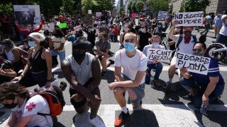 People protesting the death of George Floyd kneel to pray at Lafayette Square next to the White House