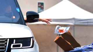 A driver drops off her coronavirus test at a COVID-19 testing site in Los Angeles on June 24, 2020.