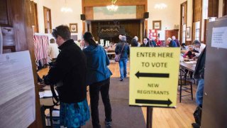 In this Nov. 8, 2016, file photo, voters cast their ballots in the presidential election at the Sutton town hall in Sutton, New Hampshire.