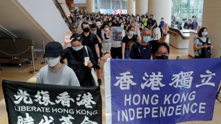 Protesters hold flags in a shopping mall during a protest in Hong Kong, Friday, June 12, 2020. Protesters in Hong Kong got its government to withdraw extradition legislation last year, but now they're getting a more dreaded national security law.