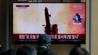 In this file photo, people watch a TV screen showing a news program reporting about North Korea's firing of projectiles with a file image at the Seoul Railway Station in Seoul, South Korea, Monday, March 2, 2020.