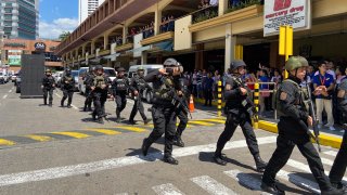 A group of armed police soldiers arrive at the Greenhills Shopping Center Monday, March 2, 2002, in Manila, Philippines. Philippine police on Monday surrounded a shopping mall in an upscale district in the Manila metropolis after gunshots rang out inside and sent shoppers rushing out in panic.