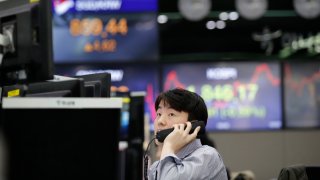 In this April 16, 2020, file photo, a currency trader watches computer monitors at the foreign exchange dealing room in Seoul, South Korea.