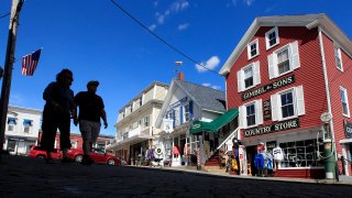 Tourists walk by newly reopened shops, Tuesday, June 9, 2020, in Boothbay Harbor, Maine.