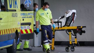 In this April 28, 2020, file photo, members of a DYA Navarra ambulance transfer a patient in the Navarra Hospital Complex during Pandemia COVID-19 in Pamplona, Navarra, Spain.