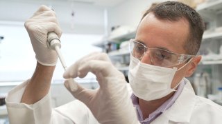 In this image from video provided by Washington University, researcher Nicolas Barthelemy works on a p-tau217 test for Alzheimer's disease at a laboratory in St. Louis, Mo., July 27, 2020.