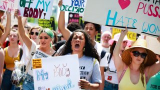 Demonstrators hold signs during a protest against Georgia's "heartbeat" abortion bill outside of the Georgia State Capitol building in Atlanta, Georgia, U.S., on Saturday, May 25, 2019. People gathered to protest the state's recently passed House Bill 481, which would ban abortion after a doctor can detect a fetal heartbeat usually around the sixth week of pregnancy.