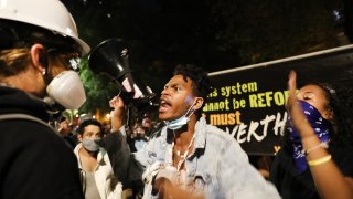 Protesters have a fight as they gather in protest in front of the Mark O. Hatfield federal courthouse in downtown Portland as the city experiences another night of unrest on July 28, 2020 in Portland, Oregon. For over 56 straight nights, protesters in downtown Portland have faced off in often violent clashes with the Portland Police Bureau and, more recently, federal officers. The demonstrations began to honor the life of George Floyd and other black Americans killed by law enforcement and have intensified as the Trump administration called in the federal officers.