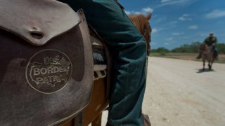 The U.S. Border Patrol logo is seen on a satchel while agents work on horseback near Carrizzo Springs, Texas, U.S., on Thursday, July 3, 2014. The Border Patrol finds an average of one corpse a day in the badlands near the U.S.-Mexico border; in the past 15 years, the toll has reached 5,570, exceeding all U.S. combat deaths for the Iraq war.