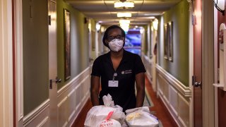 Shanika Williams wears a facemask as she delivers food in John Knox Village, a retirement community in Pompano Beach some 40 miles north of Miami, Florida on August 7, 2020.
