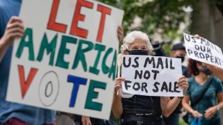 Demonstrators with Shut Down DC protest prepare to march to the home of Postmaster General Louis DeJoy in Washington, D.C., U.S., on Saturday, Aug. 15, 2020.