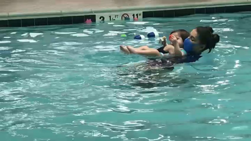 A woman teaching a child to swim.