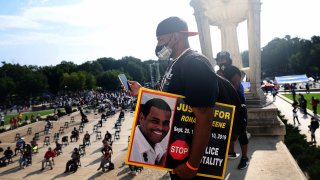 Sean Greene, brother of Ronald Greene, listens to speakers and holds sign reading “Justice for Ronald Greene” and “Stop Police Brutality” at the Lincoln Memorial during the March on Washington on August 28, 2020, in Washington, DC.