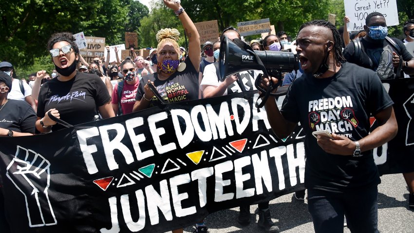 Demonstrators take part in a Juneteenth march and rally in Downtown Washington, DC, on June 19, 2020. – The US marks the end of slavery by celebrating Juneteenth, with the annual unofficial holiday taking on renewed significance as millions of Americans confront the nation’s living legacy of racial injustice. (Photo by Olivier DOULIERY / AFP) (Photo by OLIVIER DOULIERY/AFP via Getty Images)