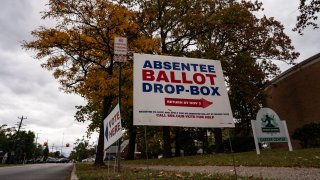 In this Oct. 15, 2020, file photo, a sign directs voters to the absentee ballot drop-box in Detroit, Michigan.