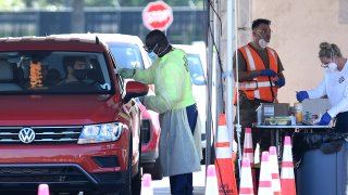 Health care workers perform COVID-19 testing at a drive-through site at Eastern Florida State College on October 9, 2020 in Palm Bay, Florida. The Florida Department of Health reports that COVID-19 cases, deaths, and hospitalizations are on the rise while U.S President Donald Trump plans to hold a rally in Sanford, Florida after contracting the disease.