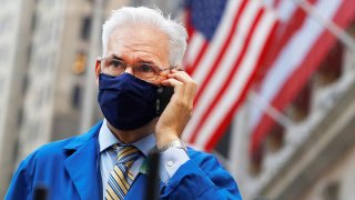 A trader speaks on a phone outside the New York Stock Exchange, November 4, 2020.