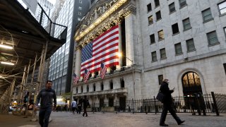 Pedestrians walk past the New York Stock Exchange.
