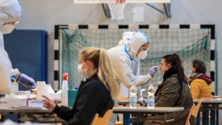 Residents undergo a free rapid antigen nasopharyngeal swab test for Covid-19 at a testing facility set up in a school sports hall, on November 20, 2020 in Bolzano, South Tyrol, Northern Italy.