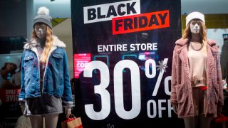 A shop window with discount signs posted is seen in New York on Thanksgiving ahead of Black Friday on November 26, 2020.
