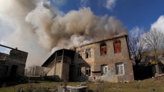 Smoke rises from a burning house in an area once occupied by Armenian forces but soon to be turned over to Azerbaijan, in Karvachar
