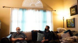 Nicholas Philbrook, right, talks to his father-in-law, Raymond Schmidt, at home